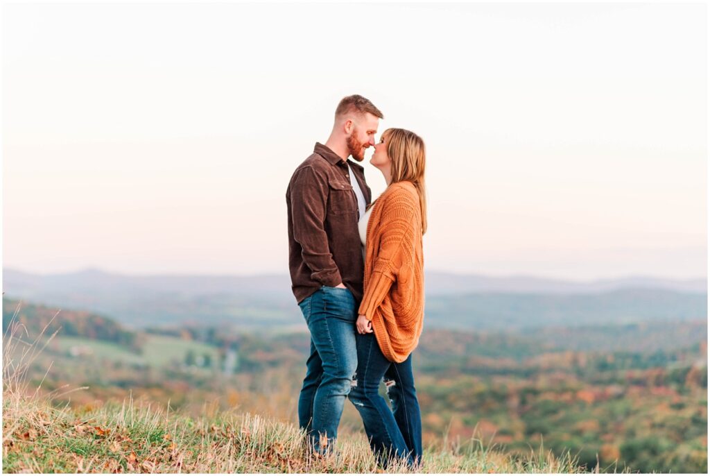 couple standing on a hill with the West Virginia mountains in the background