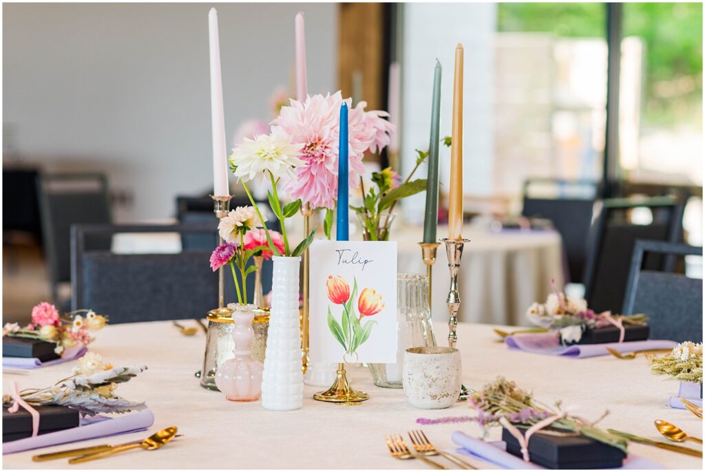 reception tables decorated with fresh flowers, mismatched candles and vases