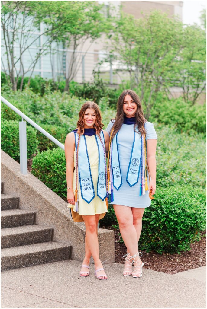 WVU law school graduate posing with her best friend at the bottom of the stairs