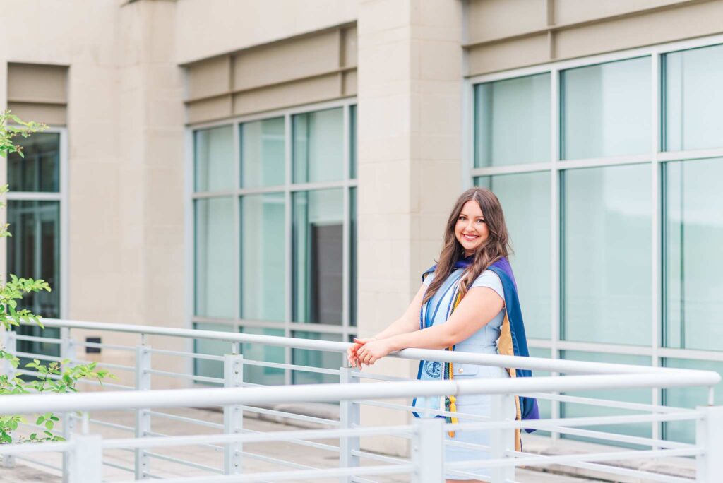 WVU law school graduate standing at a railing on campus