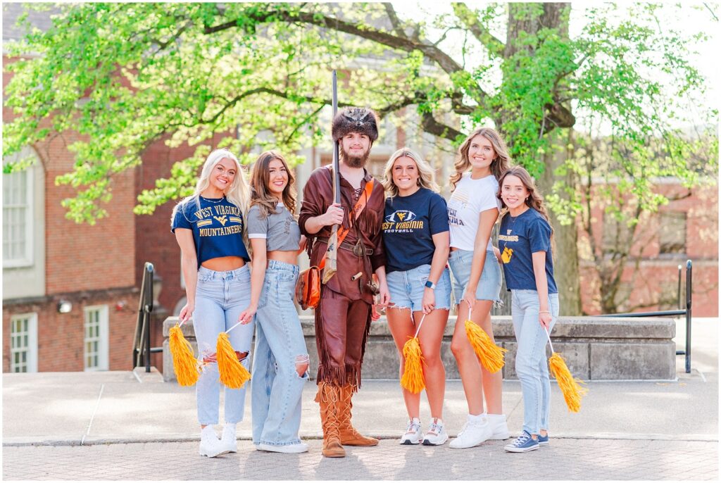 college seniors at WVU posing with the Mountaineer mascot at graduation session