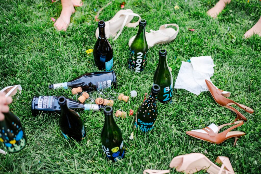 painted wine bottles and shoes scattered on the ground after a wvu grad photos session