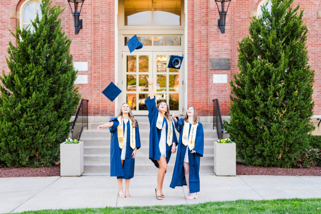 graduationcaptoss2 carrie white photography group of three wvu dental hygiene grads tossing graduation caps at the same time in front of woodburn hall in morgantown wv